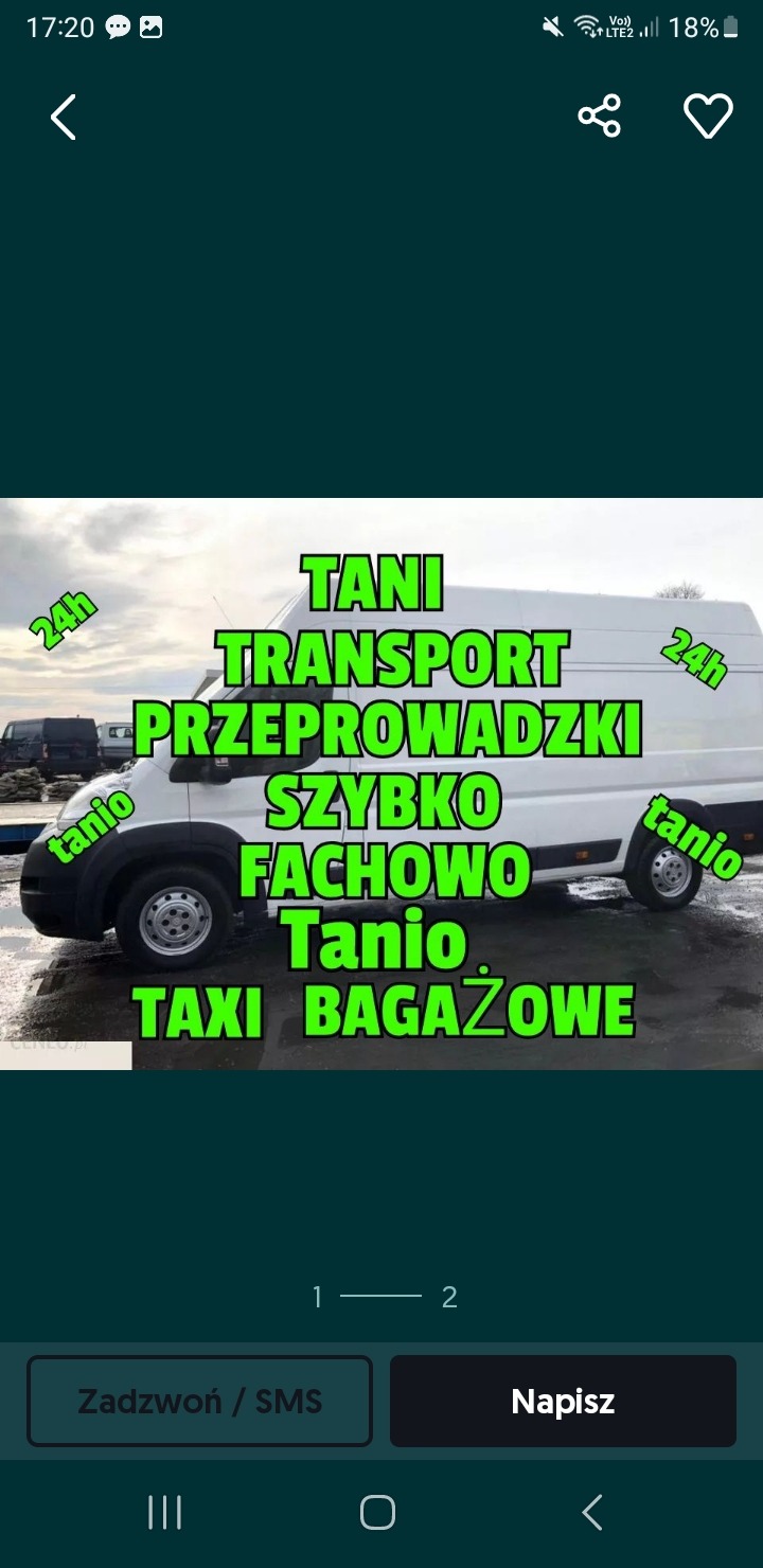 Biały bus z dużym, zielonym napisem reklamowym 'TANI TRANSPORT PRZEPROWADZKI SZYBKO FACHOWO Tanio TAXI BAGAŻOWE' oraz hasłami '24h' i 'tanio' na tle szarego parkingu.
