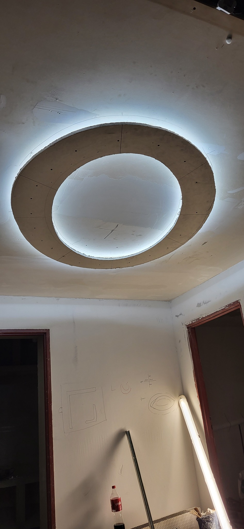 Sufit podwieszany z oświetleniem LED w okrągłym kształcie, w trakcie montażu, widoczne ślady szpachlowania na ścianach w Kurczowie.