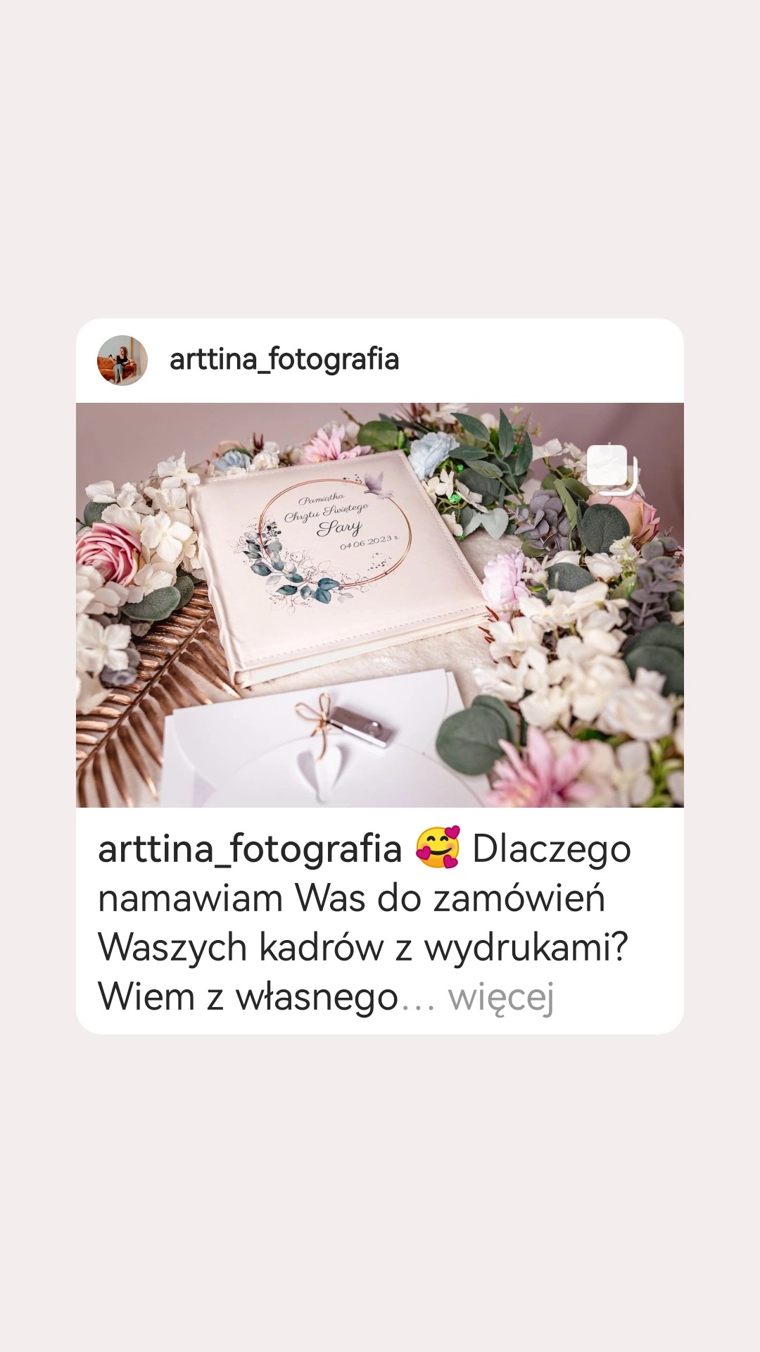 Pamiątkowy album Chrztu Świętego Sary z datą 04.06.2023, otoczony kwiatami i leżący obok pendrive'a z wyciętym sercem, prezentowany w kontekście fotografii.