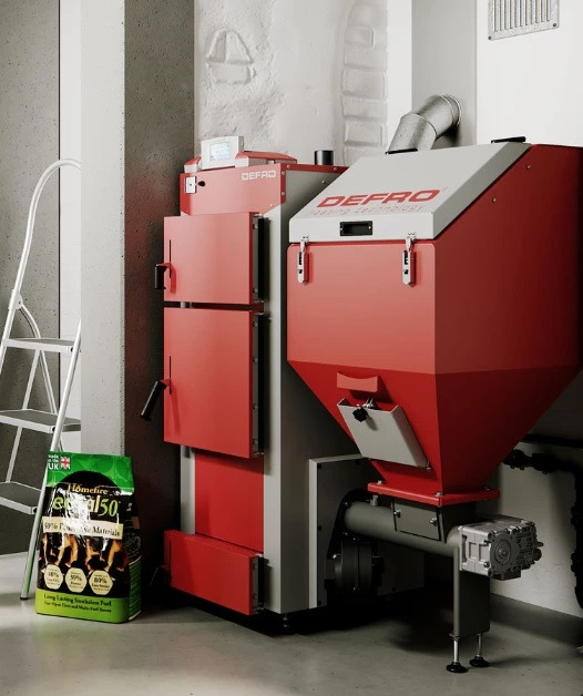 Nowoczesny, dwuczęściowy piec na paliwo stałe marki Defro, z podajnikiem i zasobnikiem na ekogroszek, obok stoi worek z paliwem