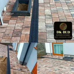 Ułożona kostka brukowa w odcieniach brązu i szarości z odpływem liniowym i studzienką rewizyjną, widok z góry na fragment posesji.