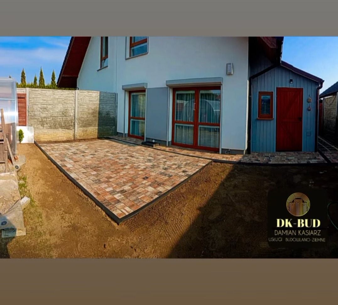 Ułożona kostka brukowa na posesji w Stargardzie, widok na dom z dwoma oknami i szopą, obrzeża z czarnego tworzywa.