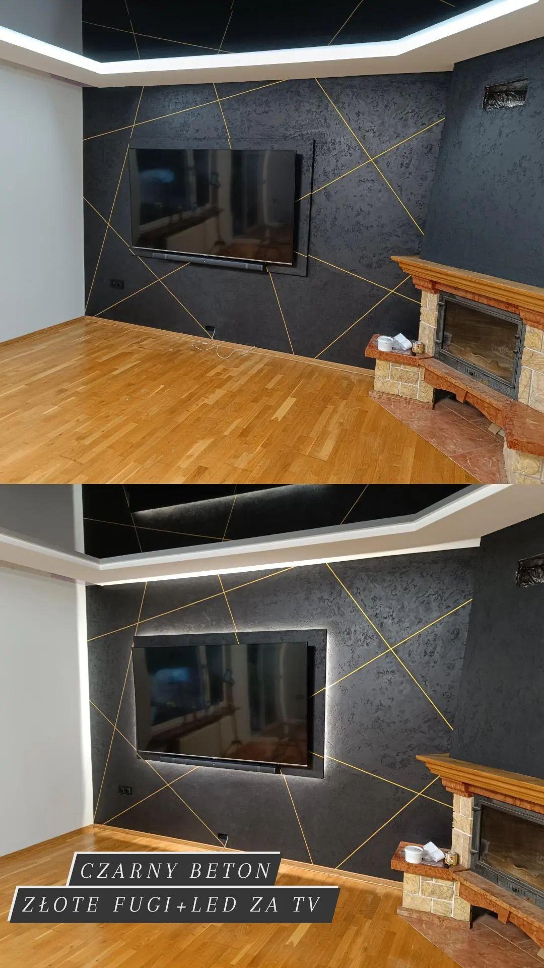 Pokój z czarną ścianą o fakturze betonu, zdobioną złotymi liniami, podświetlony telewizor LED i drewniany parkiet, widoczny kominek.