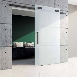Minimalistyczne drzwi przesuwne w czarnych okuciach to połączenie funkcjonalności i wyrafinowanego stylu. Ich surowy design i uniwersalna kolorystyka tworzą wyrazisty akcent w każdym wnętrzu, jednocześnie zapewniając płynność i oszczędność przestrzeni