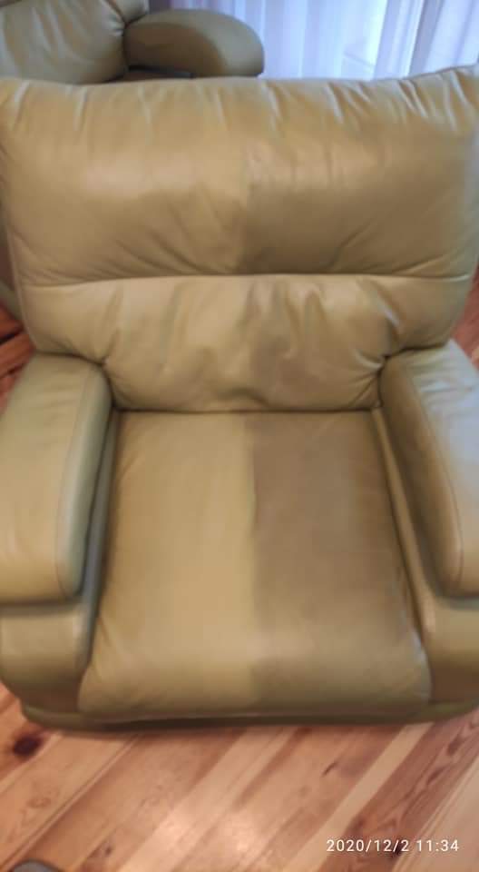 Beżowy, skórzany fotel z widoczną różnicą w czystości na środku siedziska, prawdopodobnie po czyszczeniu, na tle drewnianej podłogi.