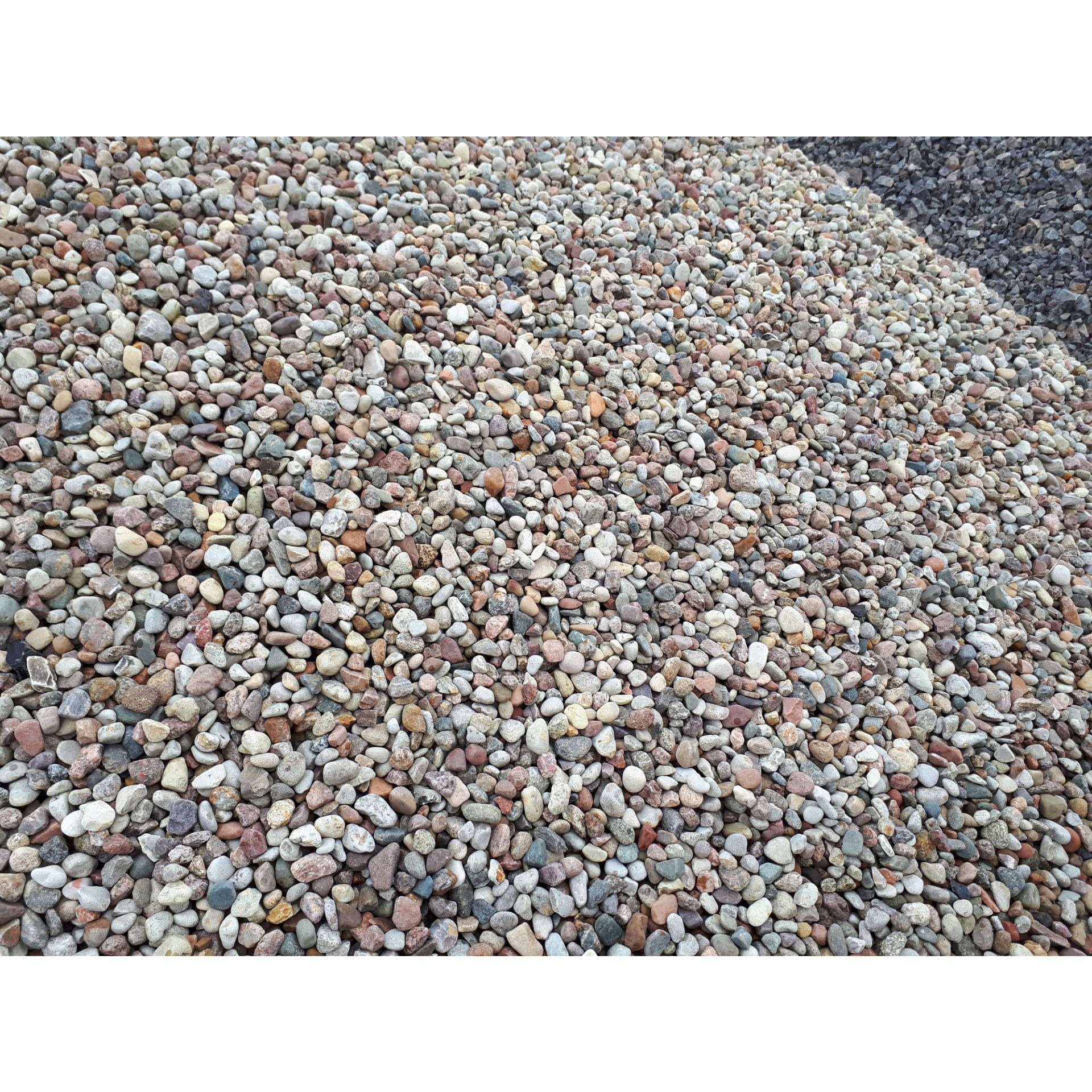 Kopalnia rzeczna: różnokolorowe otoczaki o gładkiej powierzchni, widoczne również ciemniejsze kruszywo w tle.