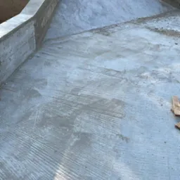 Wylany fundament pod budynek z widoczną szalunką i zacierką betonu na powierzchni płyty fundamentowej.