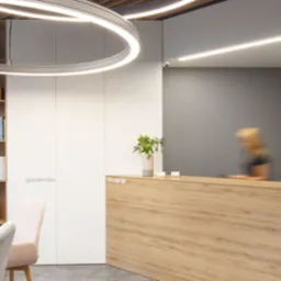 Nowoczesne wnętrze recepcji kliniki z drewnianą ladą, okrągłymi lampami sufitowymi, regałem z książkami i logo 'dental arts studio' na szarej ścianie.