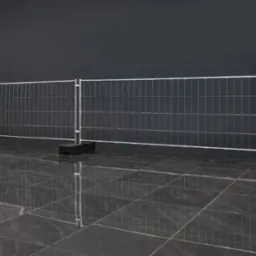 Tymczasowe ogrodzenie panelowe z siatki z metalową ramą i czarnymi podstawami na błyszczącej, ciemnej podłodze, ustawione przed ciemnoszarym tłem.