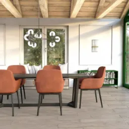 Nowoczesna jadalnia z drewnianym sufitem, pomarańczowymi krzesłami i zielonymi ramami okiennymi, wpadająca w zieleń ogrodu przez szklane ściany.