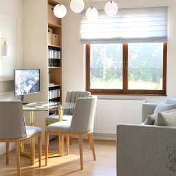 MM-Studio Projektowanie Wnętrz Marcin Martela - Jasne biuro z szklanym stołem na złotych nogach, krzesłami w odcieniach szarości i regałem z dokumentami. Duże okno z widokiem na zieleń.