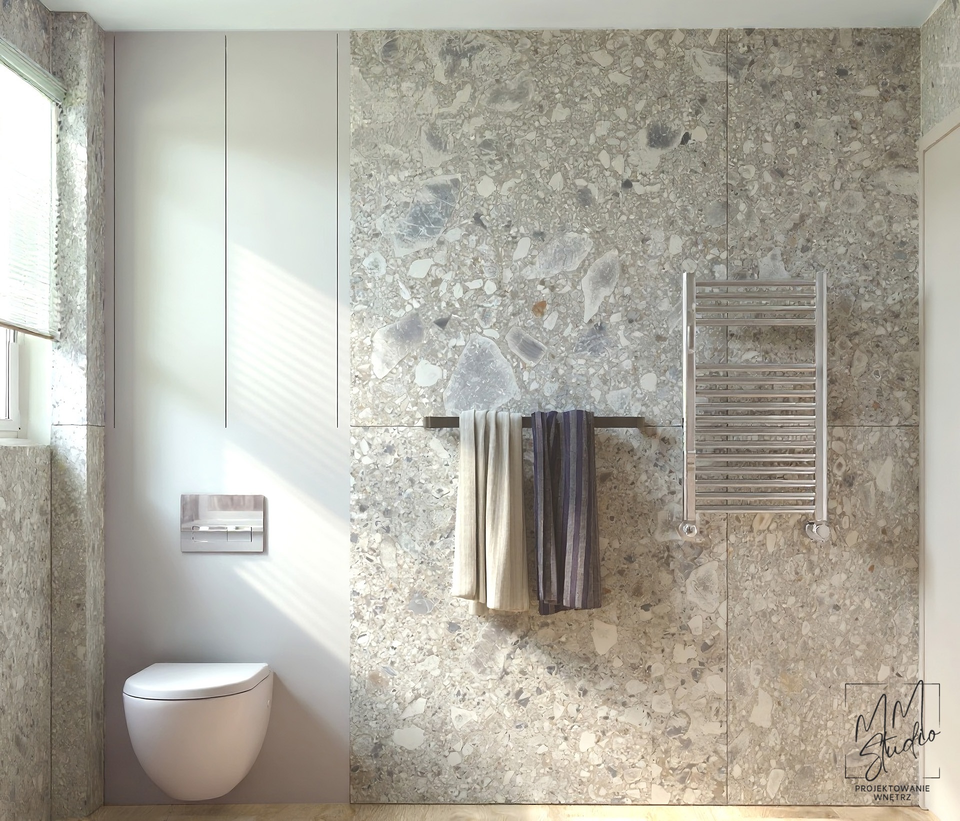Nowoczesna łazienka z toaletą podwieszaną, grzejnikiem drabinkowym i ścianą wykończoną płytkami imitującymi lastryko w odcieniach szarości. Minimalistyczny design.