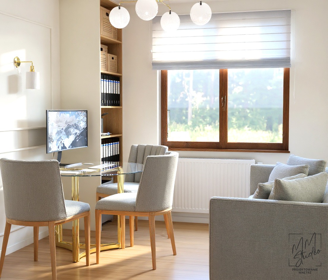 Jasne biuro z szklanym stołem na złotych nogach, krzesłami w odcieniach szarości i regałem z dokumentami. Duże okno z widokiem na zieleń.