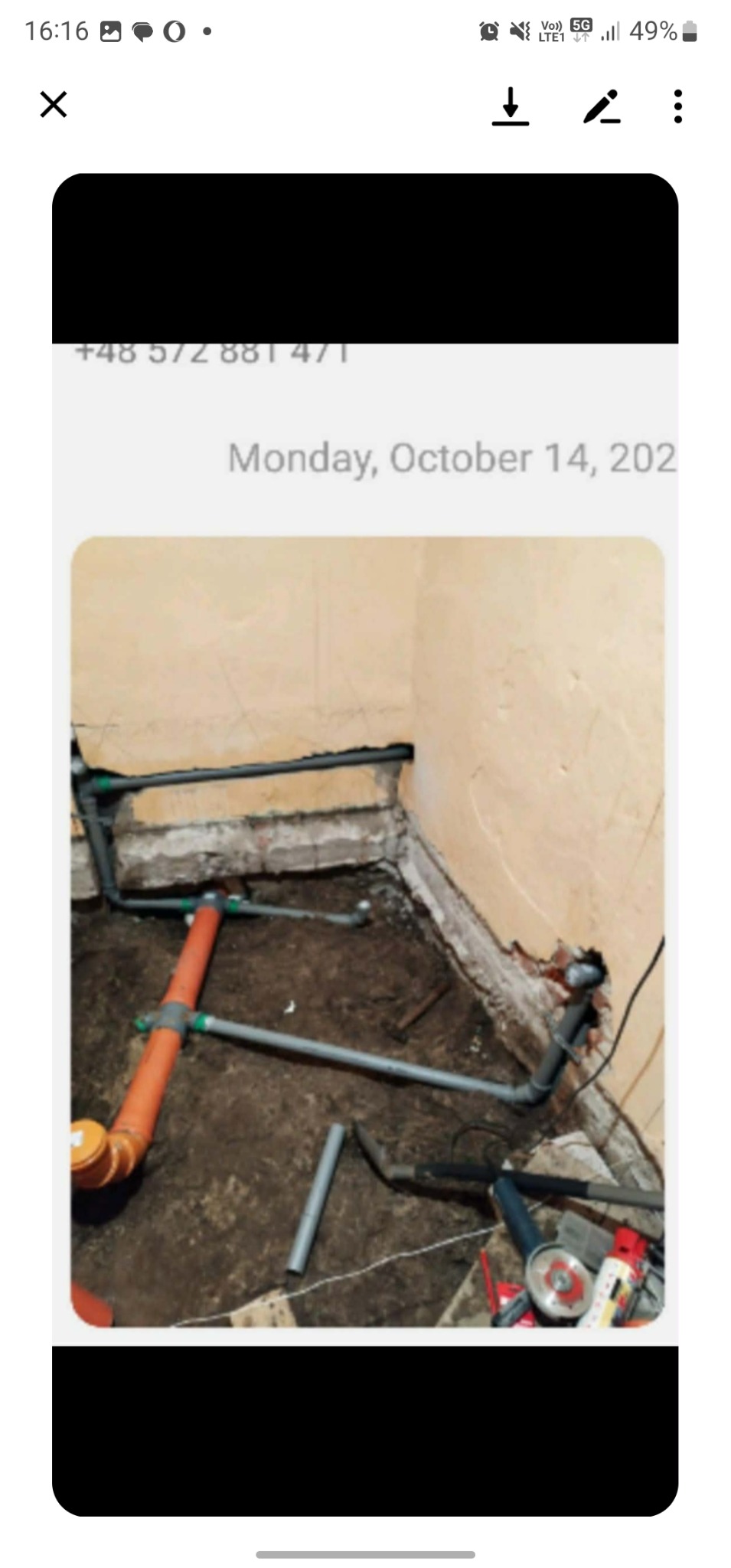 Instalacja wodno-kanalizacyjna w trakcie montażu w narożniku pomieszczenia. Widoczne rury PCV, narzędzia i fragment ściany z uszkodzonym tynkiem. Prace remontowe w toku.