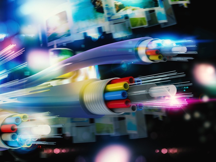 Ilustracja światłowodów z kolorowymi żyłami w Jastrzębiu-Zdroju, z efektem rozmycia i światłami w tle, sugerująca szybki przesył danych.