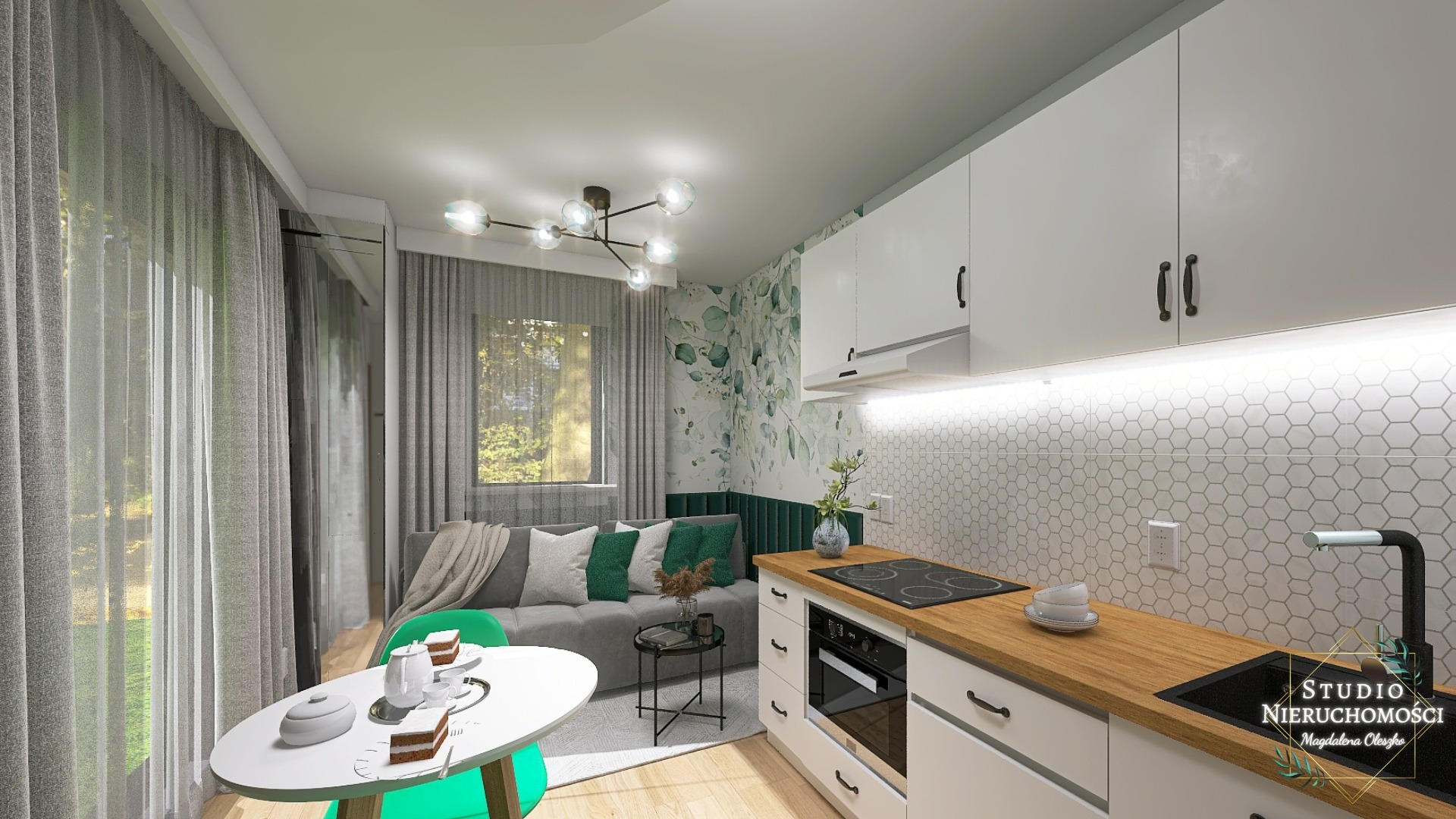 Wnętrze mieszkania: kuchnia z drewnianym blatem i białymi szafkami, widok na salon z szarą sofą, zielonymi poduszkami i tapetą w liście, na pierwszym planie okrągły stół z zielonymi krzesłami