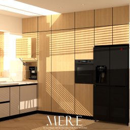 MERE Pracownia Architektury Marzena Maziarz - Nowoczesna kuchnia z drewnianymi frontami szafek, czarnym sprzętem AGD i parkietem. Promienie słoneczne wpadają przez okno z żaluzjami, oświetlając wnętrze.