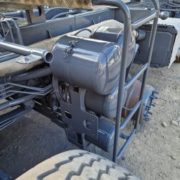 Fresz Natalia Loc - Szara rama samochodu ciężarowego z cylindrycznymi zbiornikami, po renowacji, z widoczną oponą. Elementy metalowe odświeżone, z połyskiem.