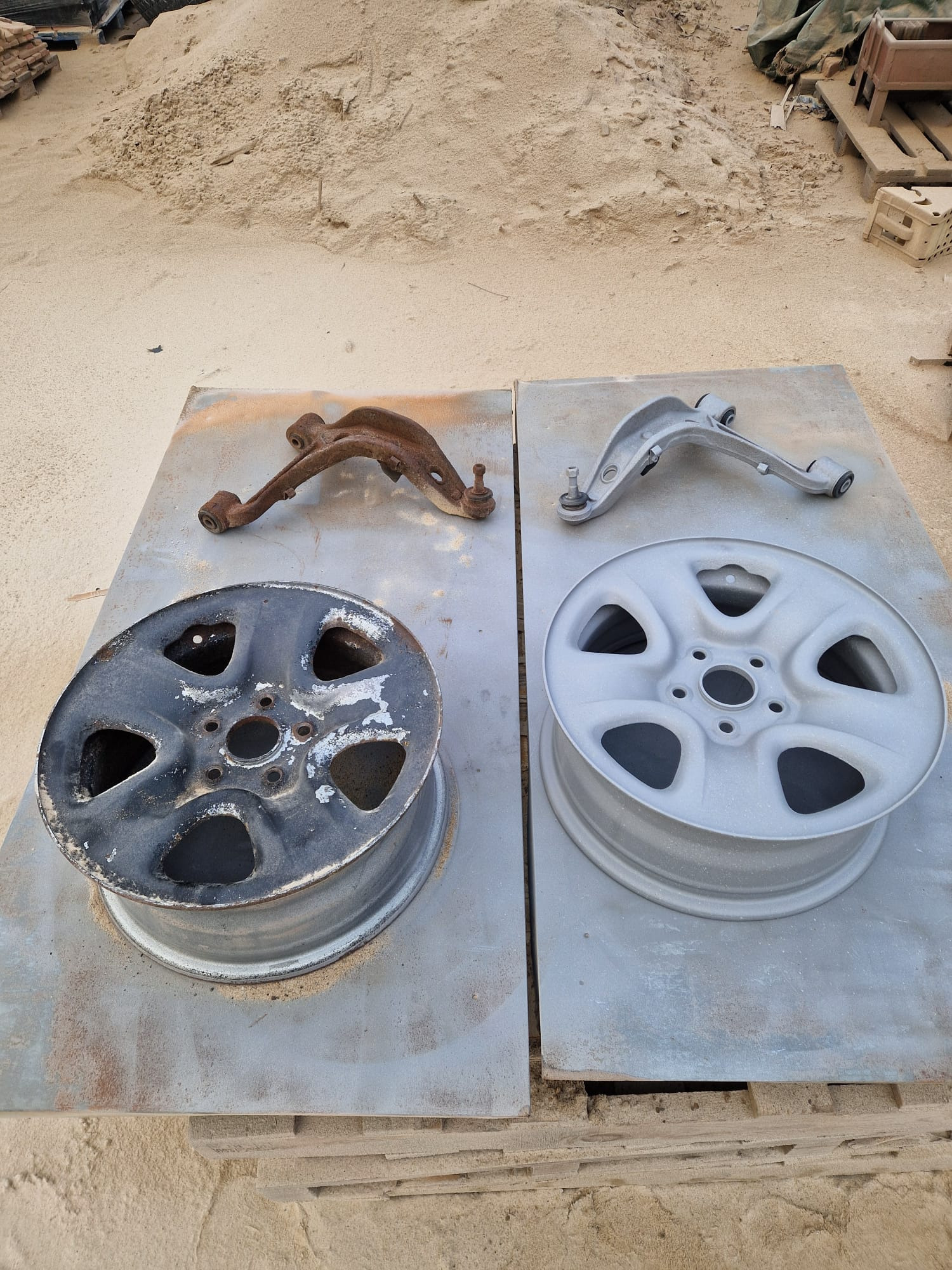 Felga i wahacz samochodowy przed i po piaskowaniu/malowaniu. Po lewej: stan skorodowany. Po prawej: element po renowacji, pokryty szarym podkładem.