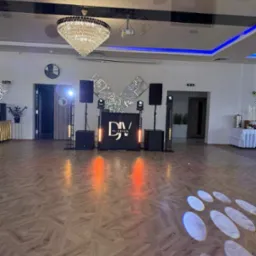 Sala balowa z parkietem i sceną DJ Venom z nagłośnieniem, oświetleniem i dekoracjami. Na suficie kryształowy żyrandol i oświetlenie LED.