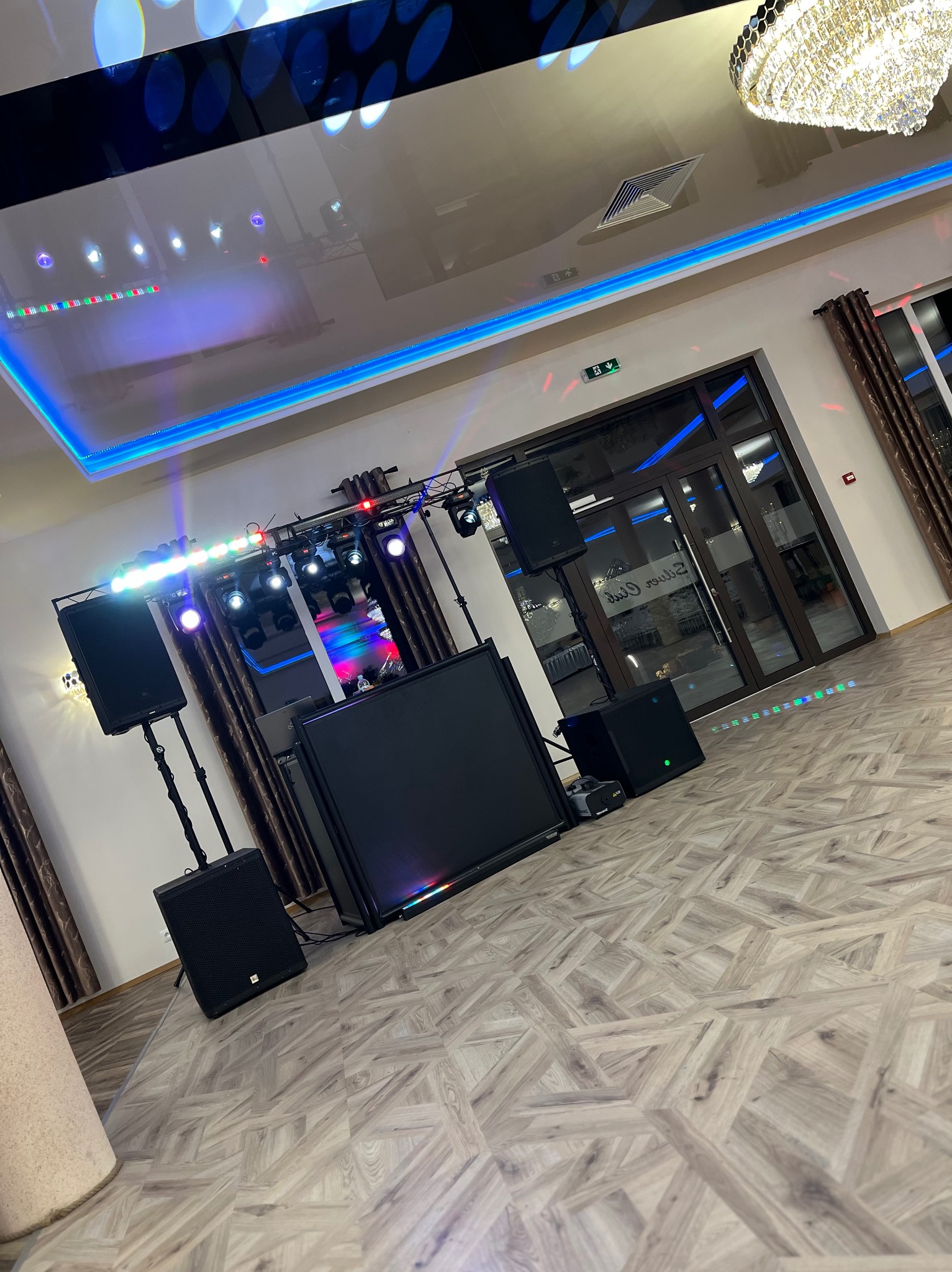 Sprzęt nagłośnieniowy i oświetleniowy w lokalu w Zagórzu, widoczne kolumny głośnikowe, konsoleta DJ-ska oraz oświetlenie sceniczne.