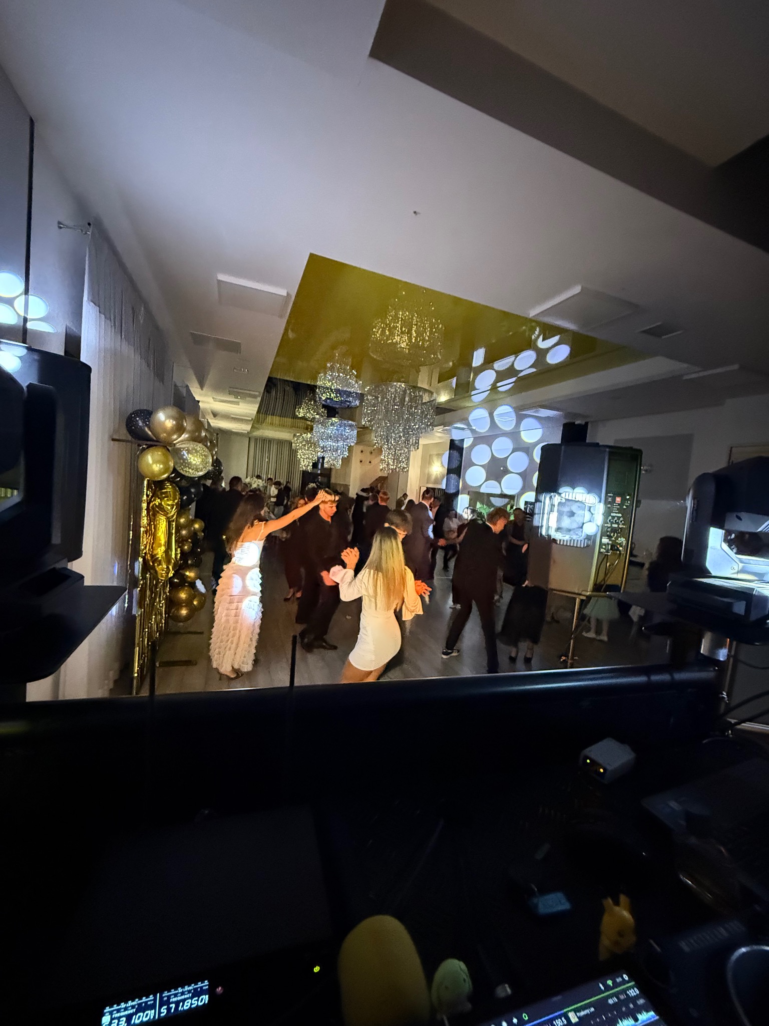 Parkiet taneczny z oświetleniem i bawiącymi się gośćmi, widziany z perspektywy DJ-a w Zagórzu. Dekoracje balonowe i efekty świetlne.