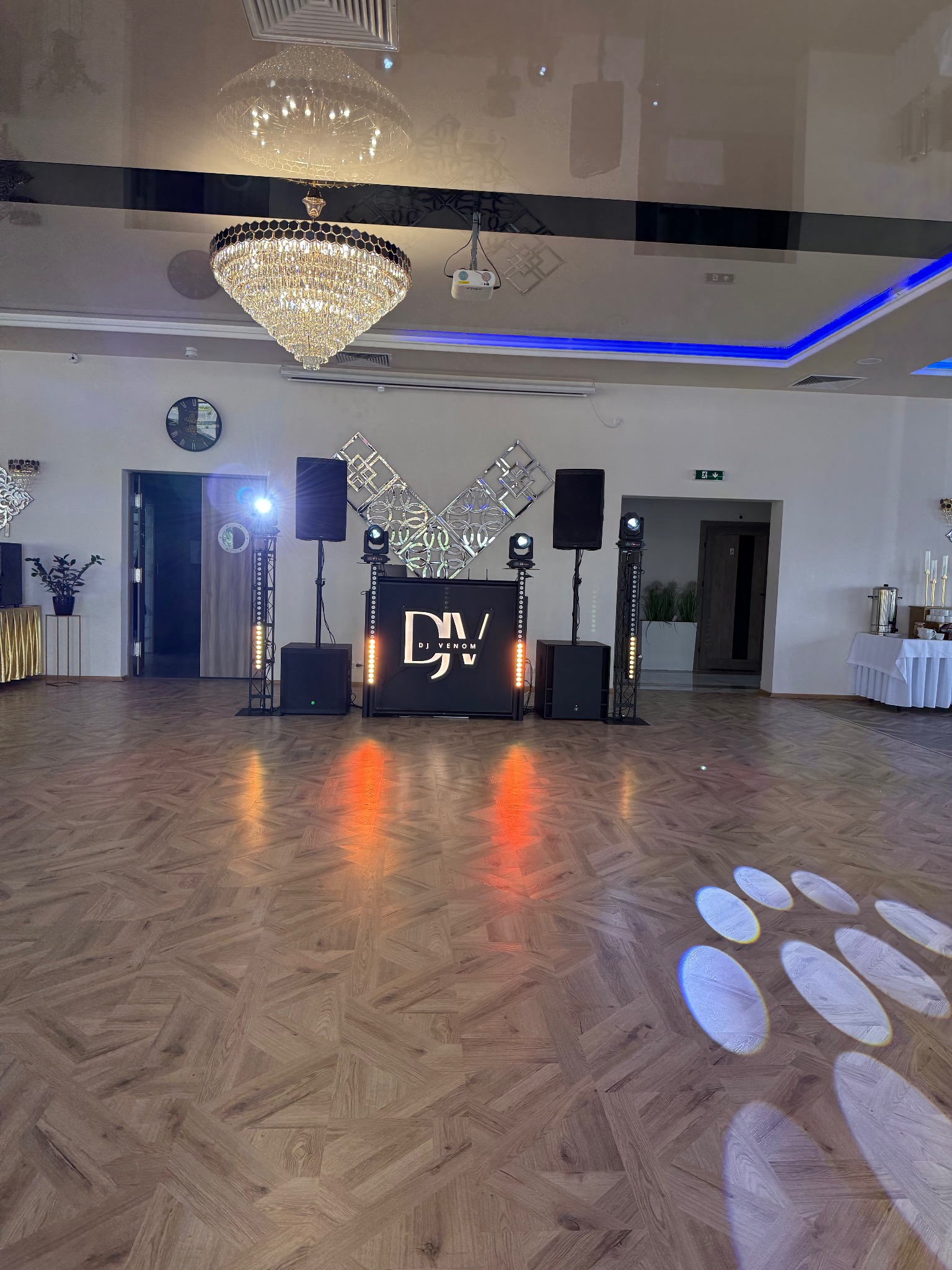 Sala balowa z parkietem i sceną DJ Venom z nagłośnieniem, oświetleniem i dekoracjami. Na suficie kryształowy żyrandol i oświetlenie LED.