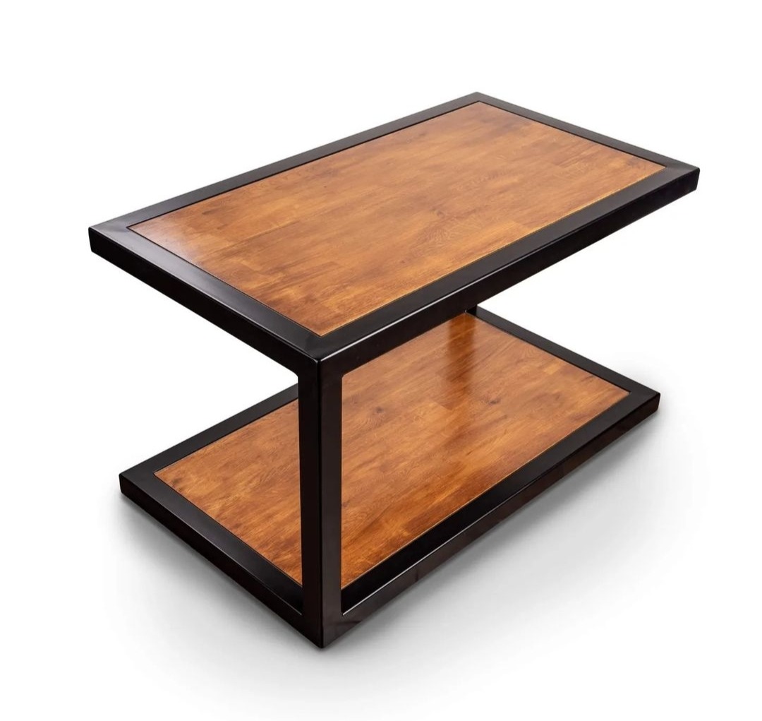 Dwupoziomowy stolik kawowy z drewnianym blatem i czarną metalową ramą, widoczny z perspektywy lekko z góry na białym tle.