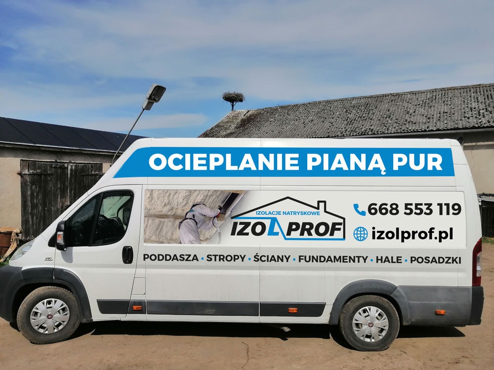 Biały samochód dostawczy z reklamą natryskowej izolacji pianą PUR, z widocznym pracownikiem w kombinezonie podczas aplikacji izolacji przez okno, na tle budynku z gniazdem bocianim na dachu.
