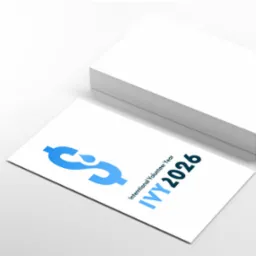 Stos wizytówek w Konstancin-Jeziornej z niebieskim logo stylizowanym na znak dolara z kroplą wody, oznaczające 'Intentional Volunteer Year IVY 2026'.