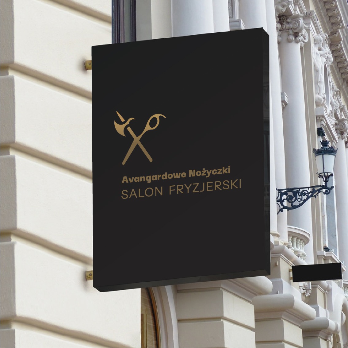 Czarny szyld salonu fryzjerskiego 'Avangardowe Nożyczki' z złotym logo przedstawiającym skrzyżowane nożyczki i grzebień, zamontowany na elewacji budynku z kolumnami.