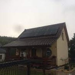 Sunvoltec - Dom jednorodzinny z panelami słonecznymi na dachu, widoczny z poziomu gruntu, pochmurne niebo w tle.