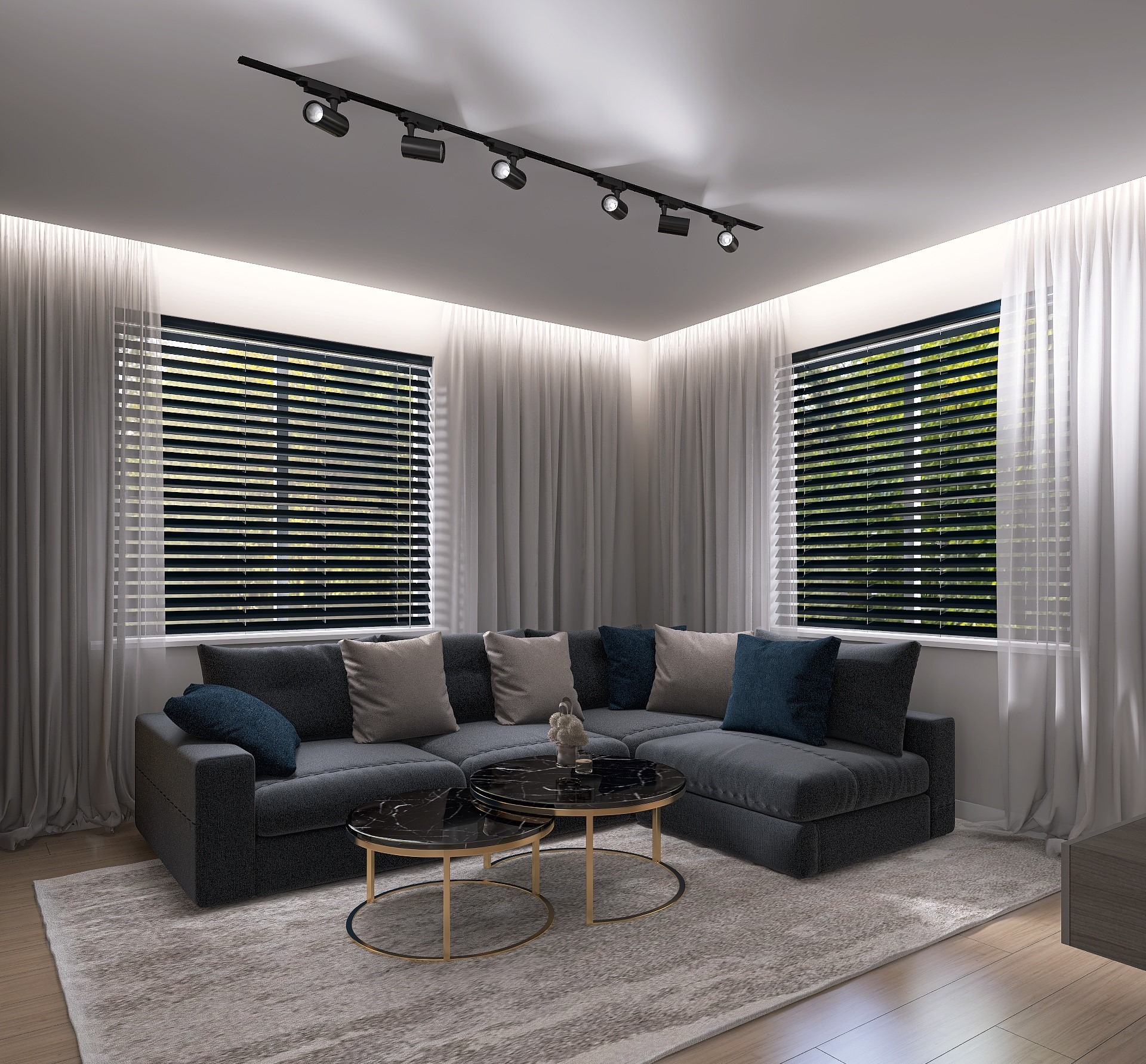 Szary narożnik z poduszkami w salonie z dwoma okrągłymi stolikami kawowymi z czarnym blatem i złotymi nogami, oświetlenie punktowe na suficie, zasłony i żaluzje w oknach.