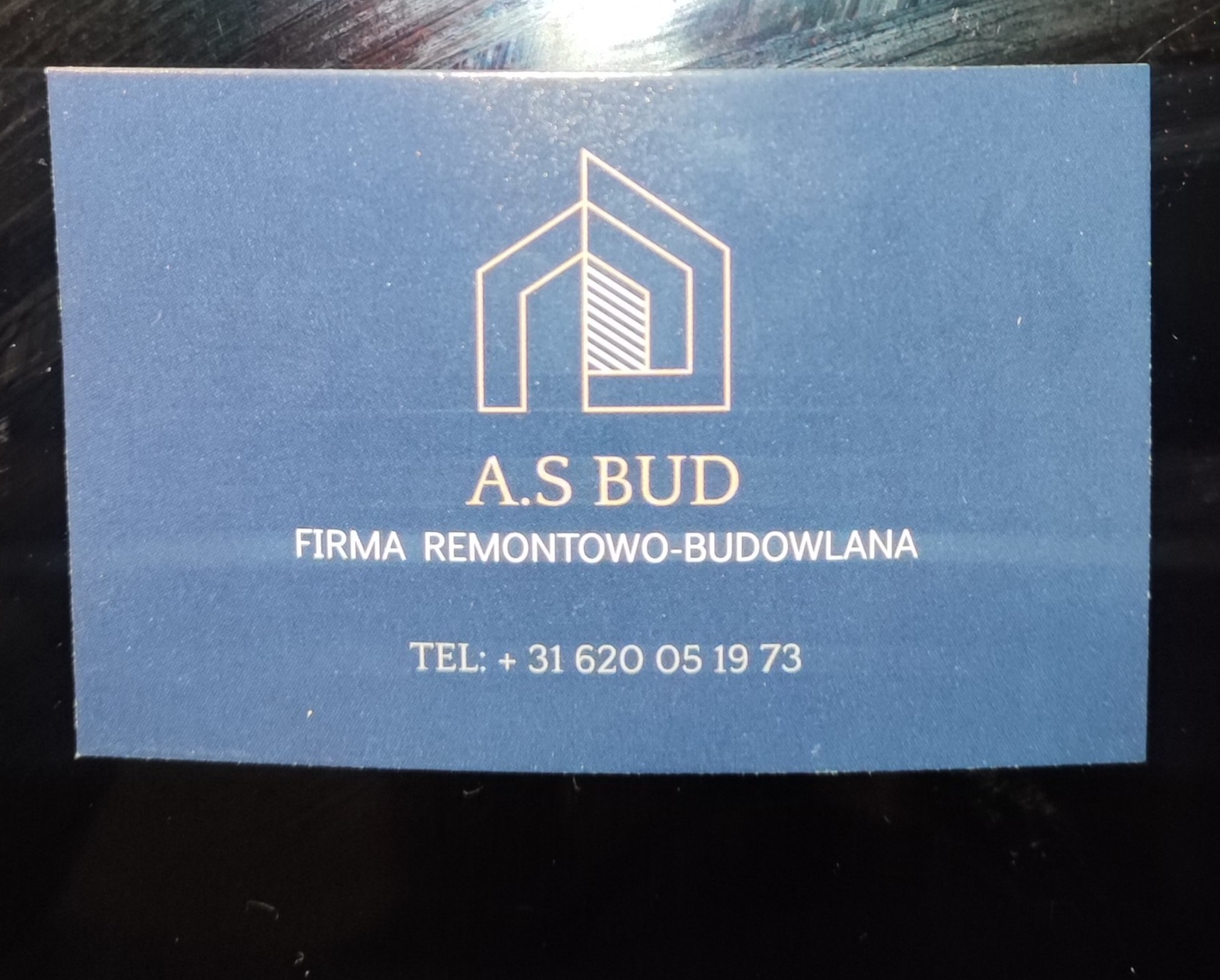 Wizytówka firmy A.S BUD z logo przedstawiającym schematyczny dom i numerem telefonu. Firma remontowo-budowlana.