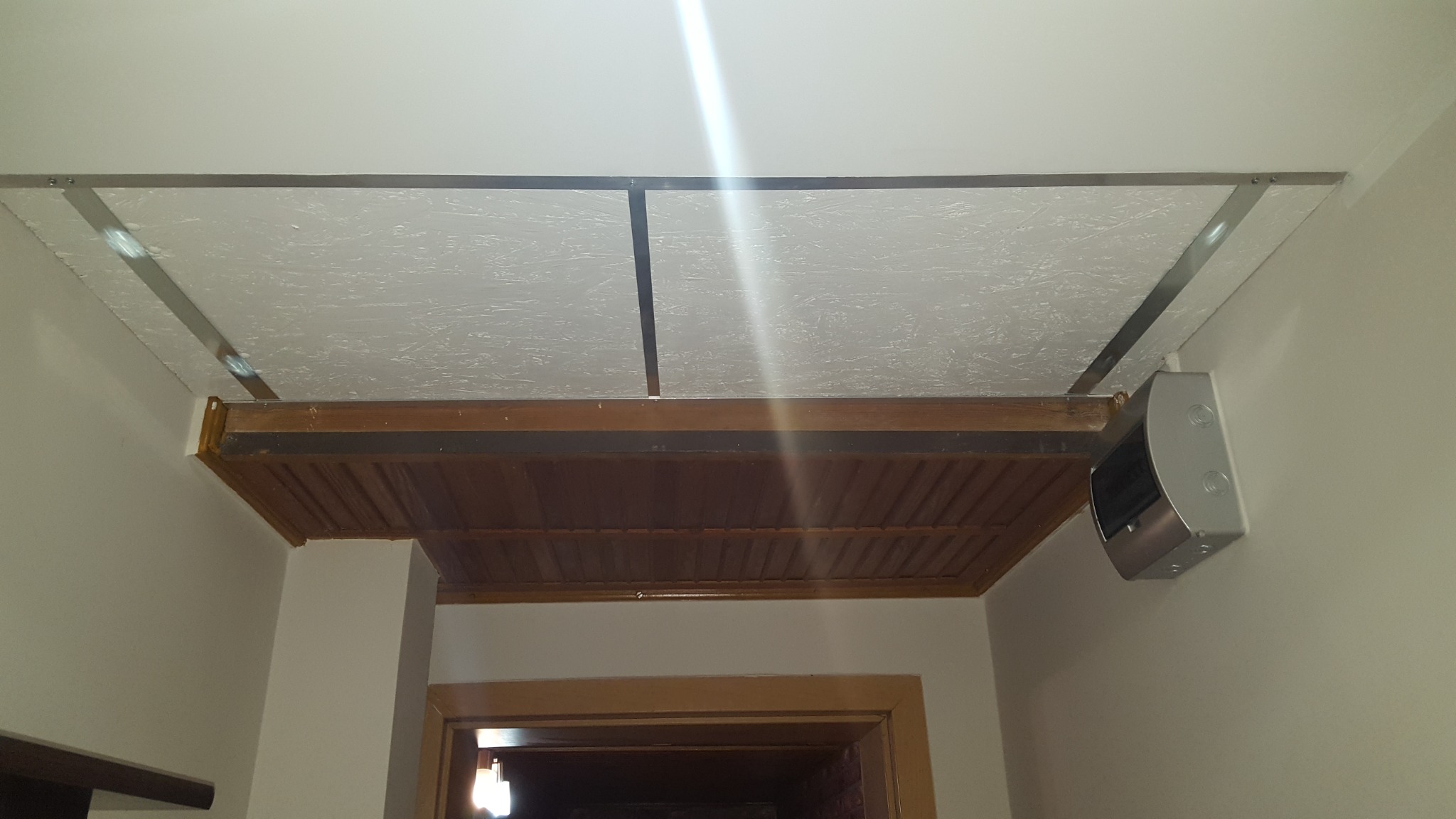 Sufit podwieszany z drewnianą konstrukcją i oświetleniem w pomieszczeniu w Łodzi.