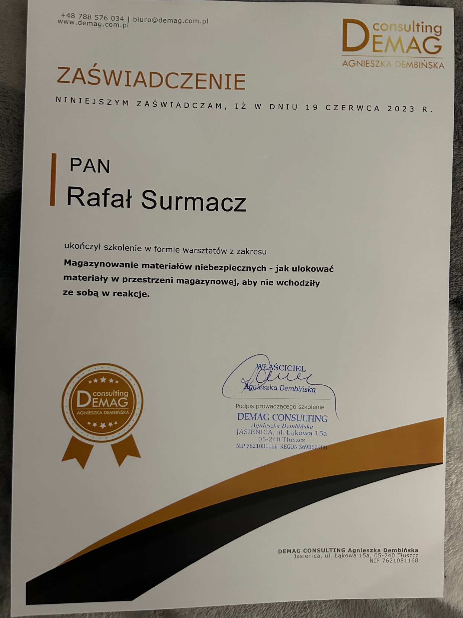 Skan zaświadczenia o ukończeniu szkolenia z zakresu magazynowania materiałów niebezpiecznych, wydanego przez Demag Consulting dla Rafała Surmacza, z podpisem właściciela Agnieszki Dembińskiej...