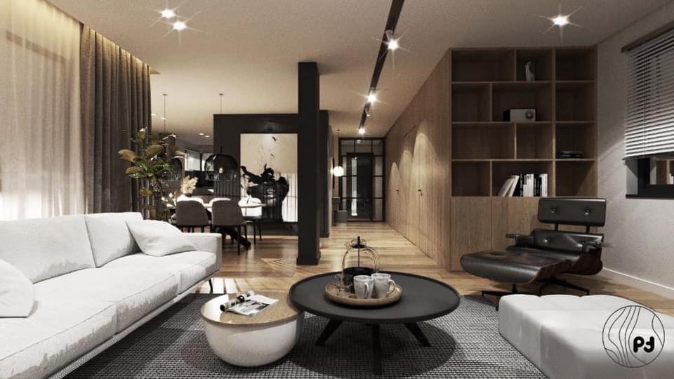 Jasne wnętrze salonu z białym narożnikiem, drewnianą podłogą i regałem w zabudowie; w tle jadalnia z czarnym stołem i krzesłami, akcenty w kolorze czarnym, oświetlenie punktowe.