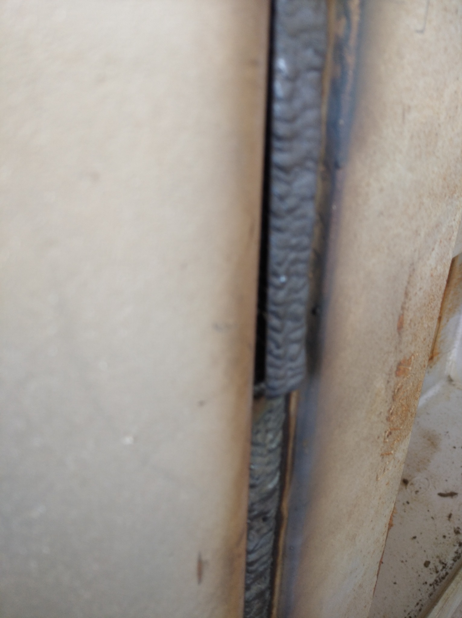 Spoina łącząca dwie metalowe powierzchnie, widoczne ślady obróbki termicznej i nierówności