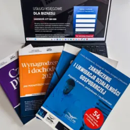 Laptop wyświetlający stronę internetową firmy księgowej Space Tax, obok leżą książki i dzienniki z zakresu prawa podatkowego i rachunkowości, w tym publikacje Infor.pl.