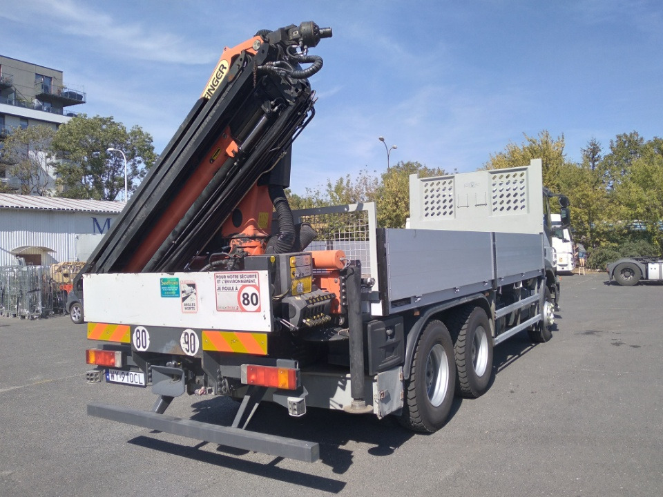 Ciężarówka z dźwigiem hydraulicznym Palfinger na parkingu, widok z tyłu, z naklejkami ostrzegawczymi i tablicami informacyjnymi.