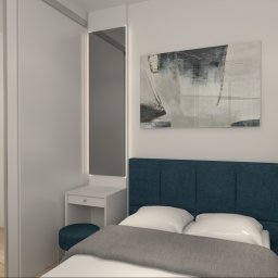 TS STYL MEBLE TOMASZ SIWCZYK - Wizualizacja sypialni z łóżkiem z niebieskim zagłówkiem, szafką nocną z wazonem, toaletką z lustrem podświetlanym LED i obrazem na ścianie, obok wejście do garderoby z drewnianą podłogą.