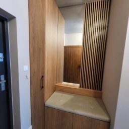 TS STYL MEBLE TOMASZ SIWCZYK - Drewniana zabudowa przedpokoju z szafą, siedziskiem z tapicerowanym obiciem i lustrem z dekoracyjnymi lamelami.