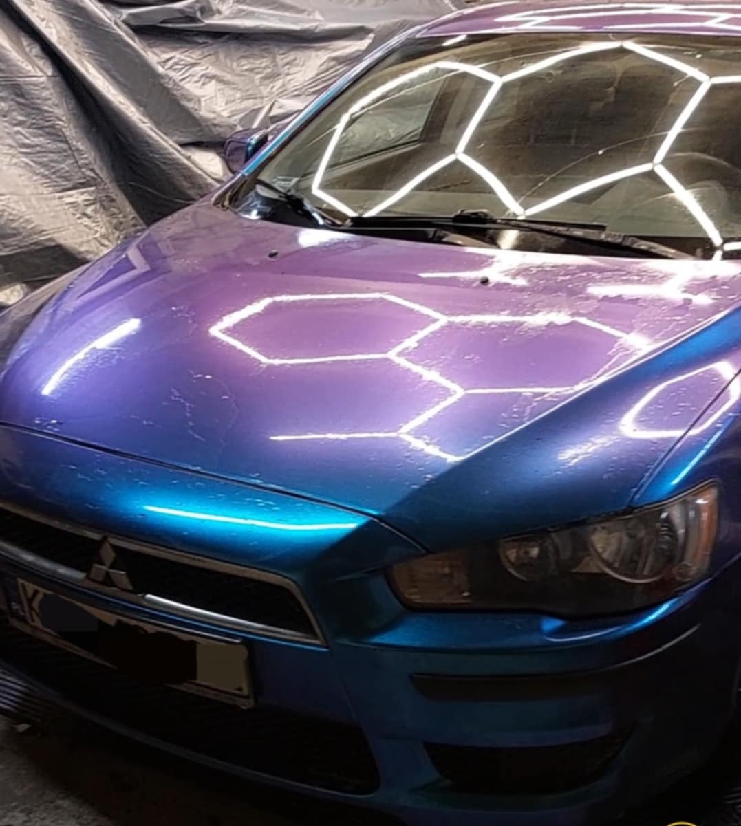 Mitsubishi Lancer z przodu, z folią zmieniającą kolor od niebieskiego do fioletowego, odbijającą światła w kształcie sześciokątów.