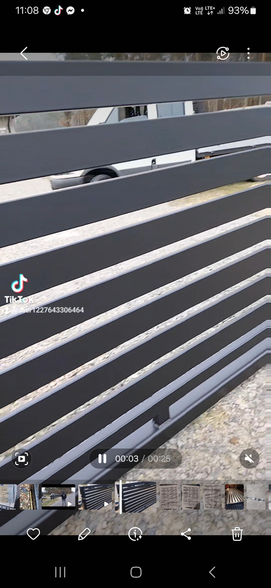 Szare, poziome panele ogrodzeniowe z widocznym fragmentem samochodu w tle, ujęcie z bliska.