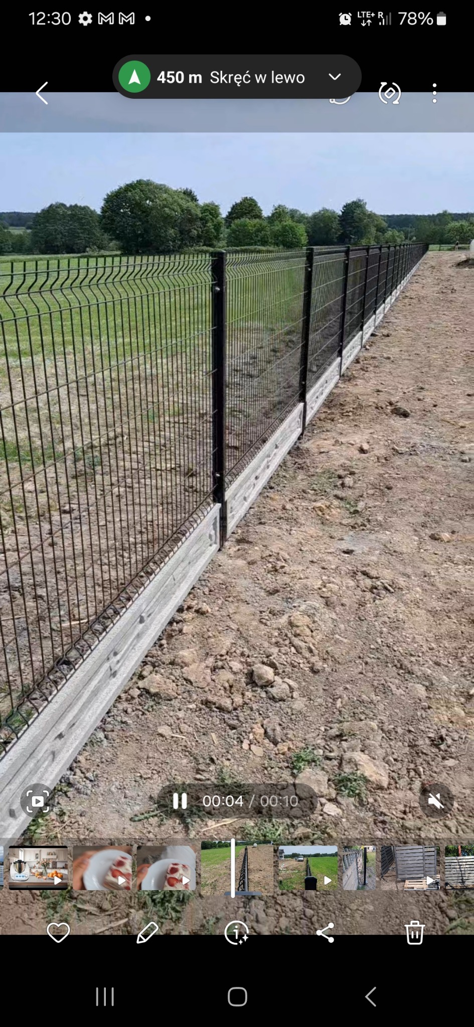 Długi, prosty odcinek czarnego ogrodzenia panelowego z podmurówką betonową, widok z boku, teren jeszcze niezagospodarowany.