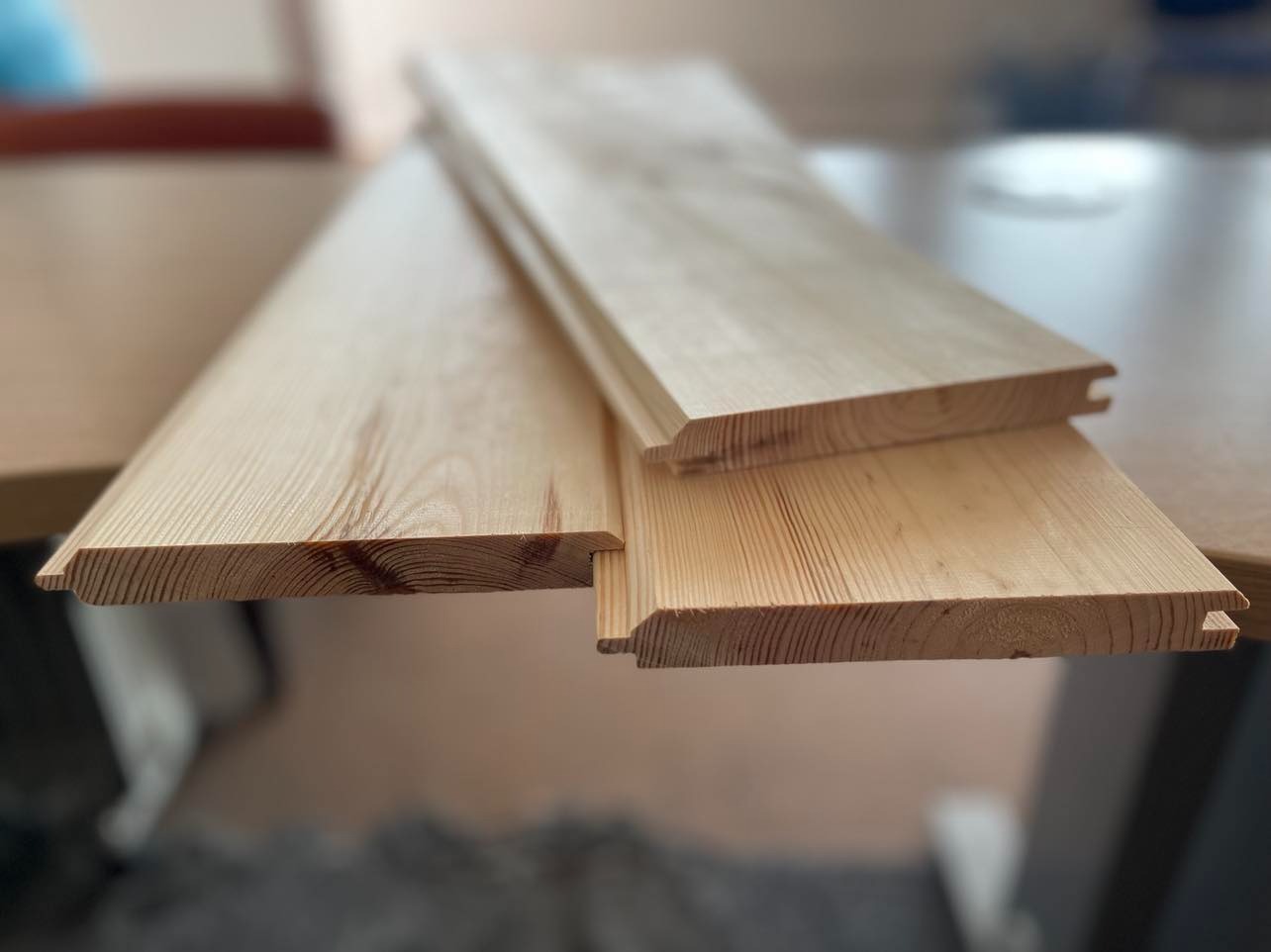 Drewniane panele boazeryjne z widocznymi profilami łączeniowymi, przygotowane do montażu przez stolarza z Pruszkowa.