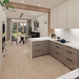 Just Design Justyna Staniszewska - Wizualizacja nowoczesnej kuchni z wyspą, beżowe szafki z minimalistycznymi uchwytami, marmurowy blat, stół z czarnymi nogami i szare krzesła w tle, widok na ogród przez duże okno.