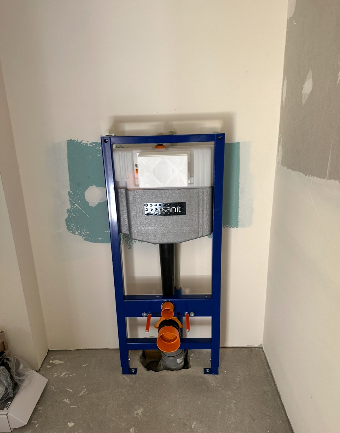 Stelaż podtynkowy WC marki Sanit, z widocznymi rurami, zamontowany w łazience w Radomiu. Ściany przygotowane do dalszych prac wykończeniowych.