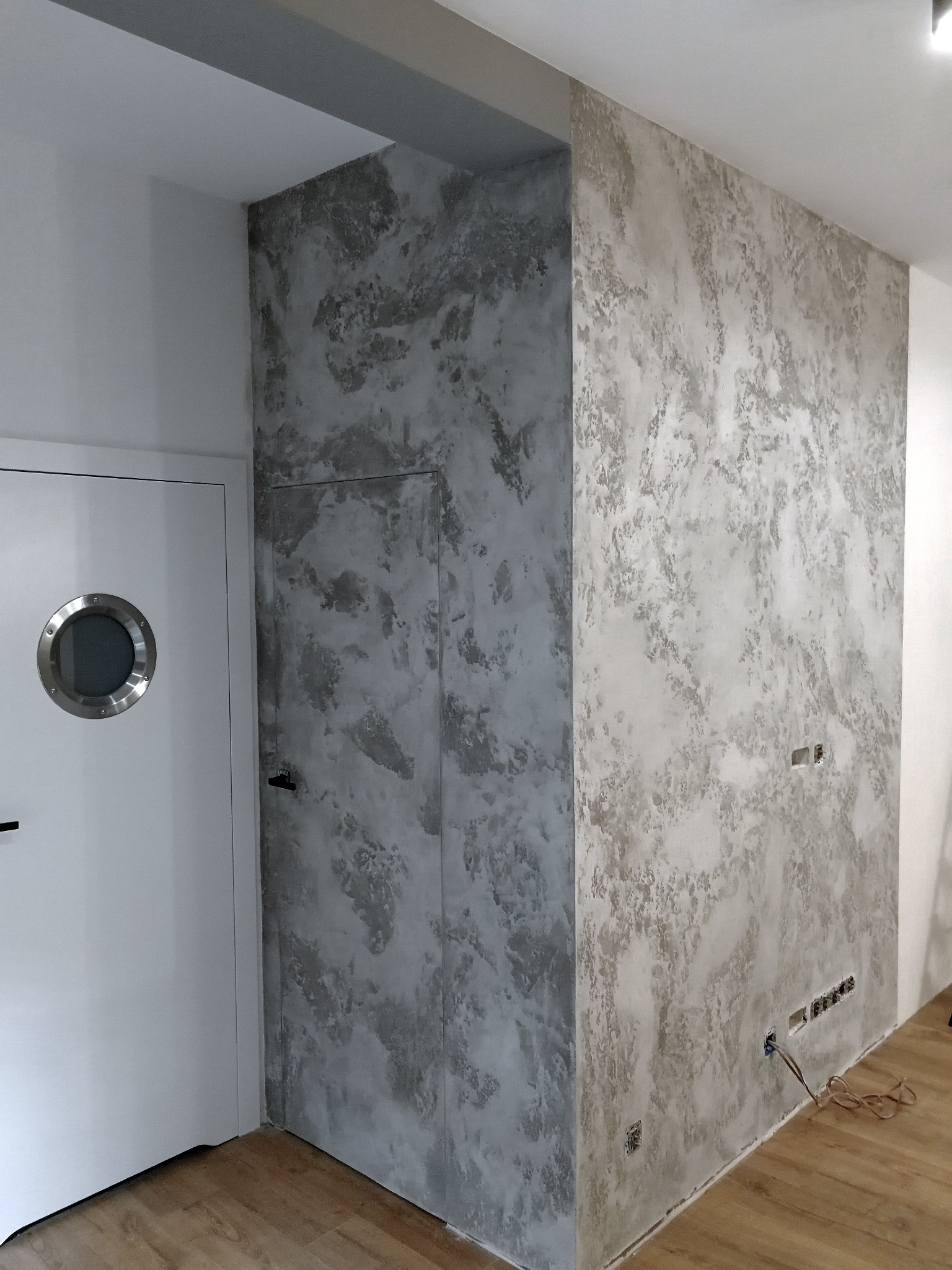 Beton architektoniczny cieniowany zastosowany na ścianie z ukrytymi drzwiami