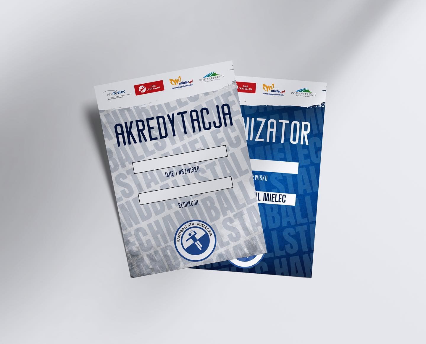 Dwa identyfikatory akredytacyjne: jeden z napisem 'Akredytacja' i miejscem na imię i nazwisko, drugi z napisem 'Organizator' i miejscem na nazwisko, oba z logo sponsorów i motywem graficznym...